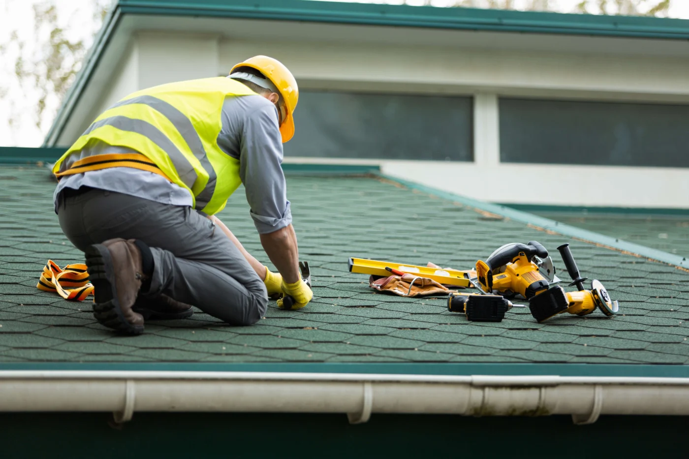 A roofer works hard to finish repairs on a residential home.