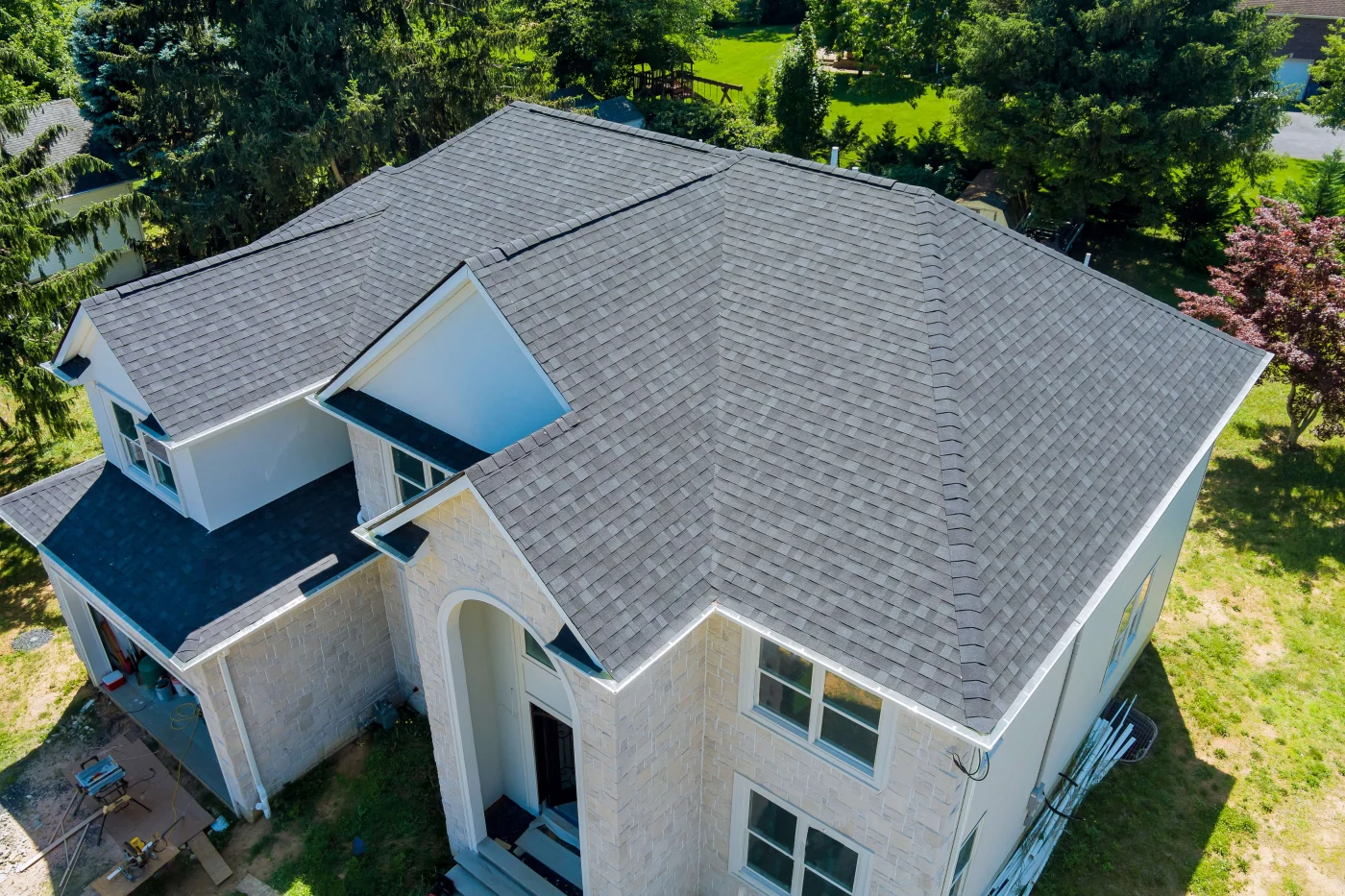 Expert Roof Repair In Clear Lake City, TX | Brinkmann Quality Roofing Services An aerial view of gray asphalt shingles on a blue house in Clear Lake City, TX.