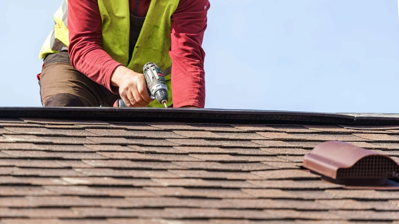 Expert Roof Repairs In Friendswood, TX | Brinkmann Quality Roofing System A roofer repairing a shingle roof in Texas during a hot summer’s day.