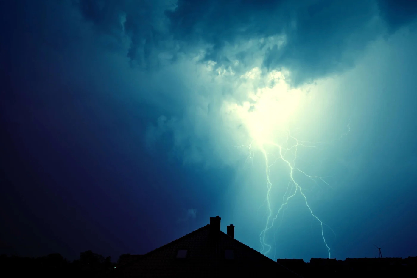 Lightning Hit The House. The silhouette of a house with a hurricane-level storm and lightning strike above.