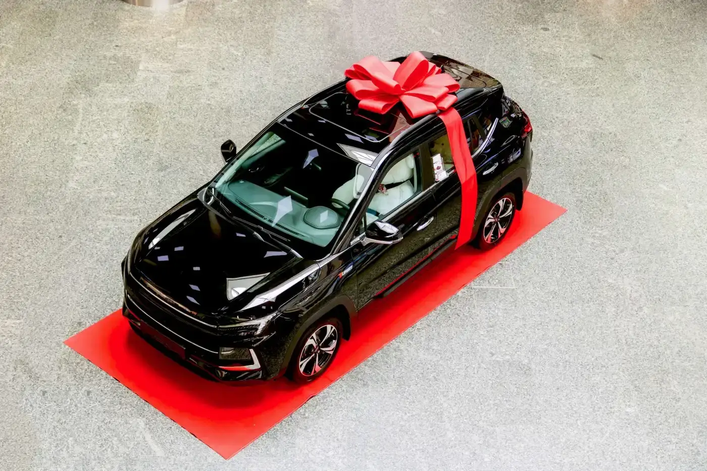Dependable Roof Maintenance in the Houston Area | Brinkmann Quality Roofing Services A shiny black toy car wrapped up with a red ribbon and bow on top.