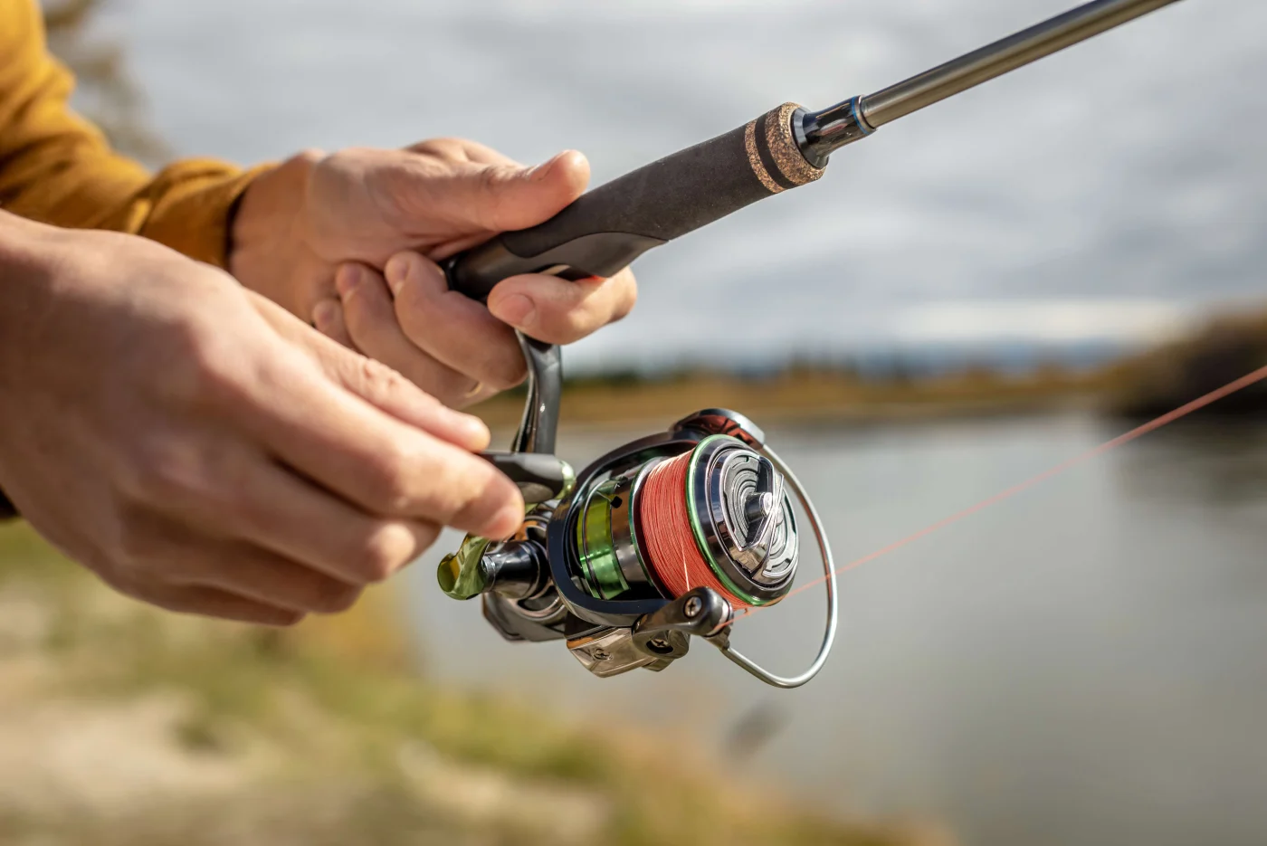 Informative Residential Roof Replacement in the Houston Area | Brinkmann Quality Roofing Services A close-up of a fisherman’s hands reeling in a catch against a backdrop of a lake.