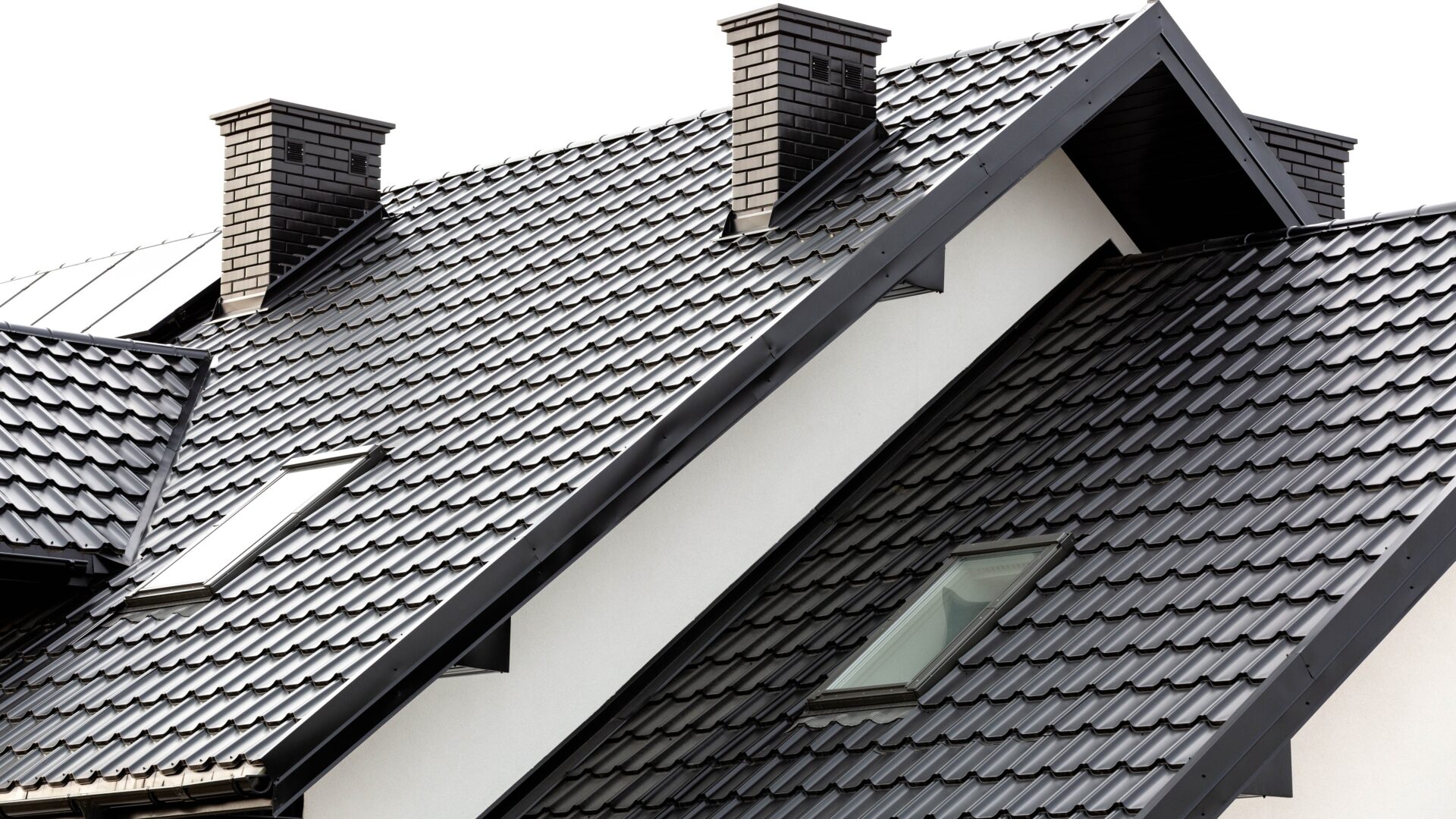 A black metal roof with a skylight and two chimneys
