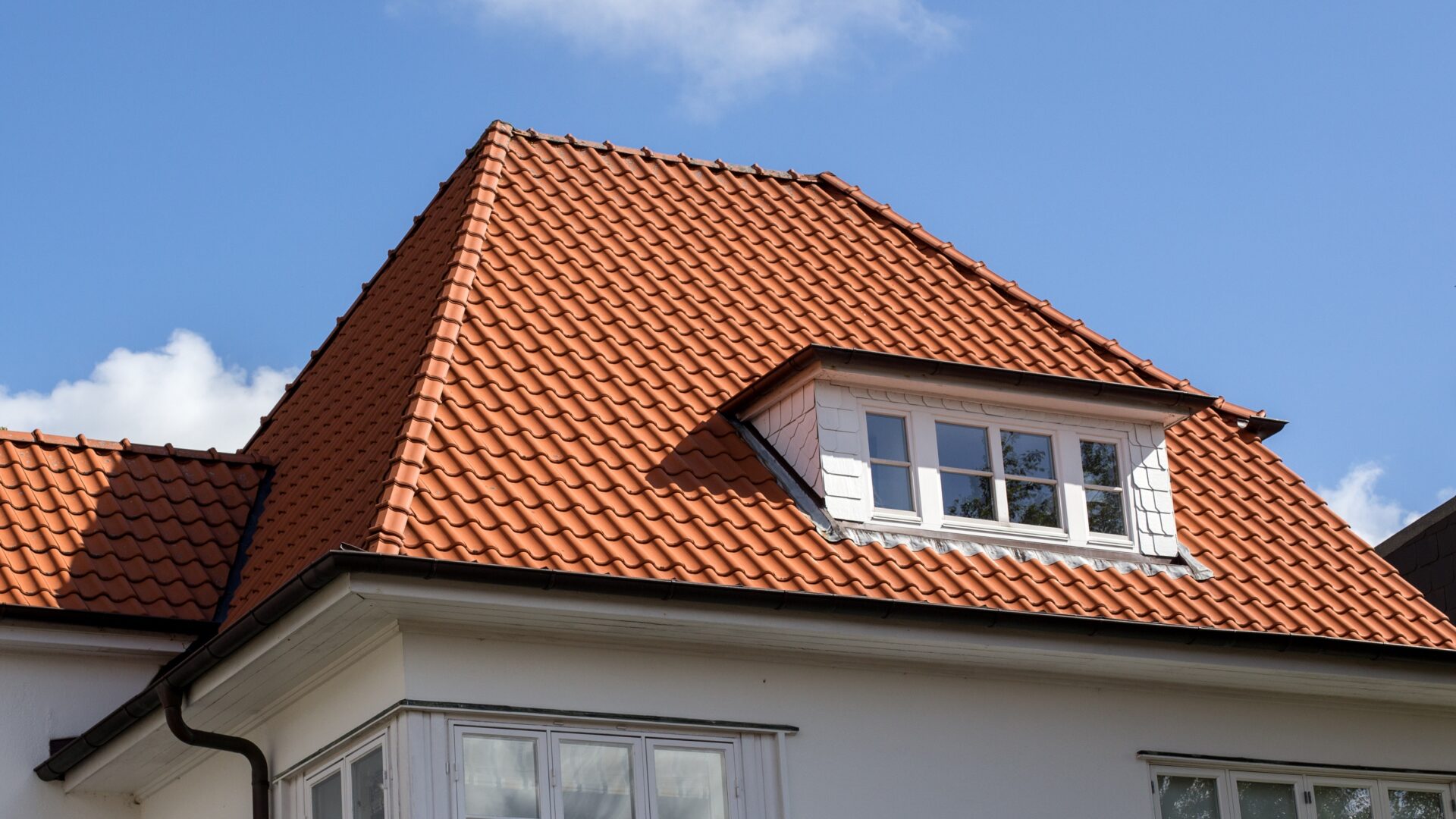An orange tile roof with a dormer window